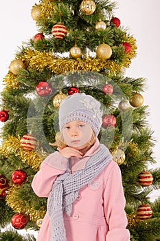 Little cute girl posing near christmas tree