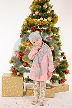 Little cute girl posing near christmas tree