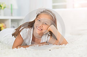 Little cute girl reading book at home