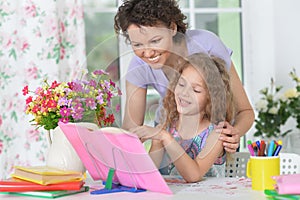 Little cute girl reading book with mother