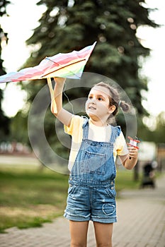 Little cute girl running with kite on summer day in the park outdoor. Summer activity