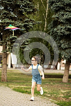 Little cute girl running with kite on summer day in the park outdoor. Summer activity