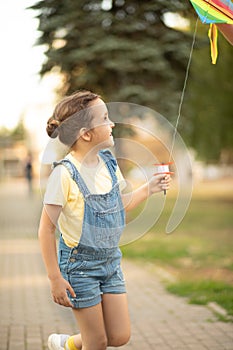 Little cute girl running with kite on summer day in the park outdoor. Summer activity