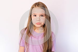 Little cute girl with a sad expression on her face, on a light background
