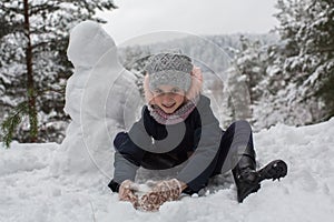 Little cute girl sculpts snowman. Game.