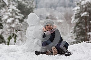 Little cute girl sculpts snowman. Winter. photo