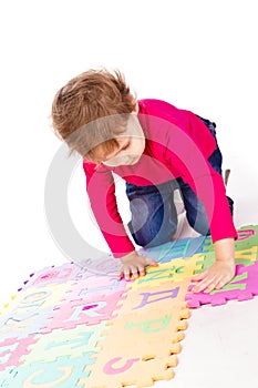 Little cute girl solving alphabet puzzle