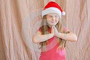 Little girl in santa claus hat dreaming about gifts for new year and christmas copy space