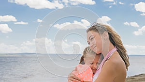 Little cute girl and young mother at beach.