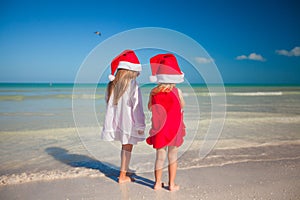 Little cute girls in Christmas hats on the exotic