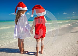 Little cute girls in Christmas hats on the exotic