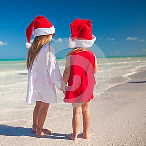 Little cute girls in Christmas hats on the exotic
