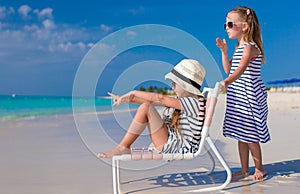 Little cute girls on white beach during vacation