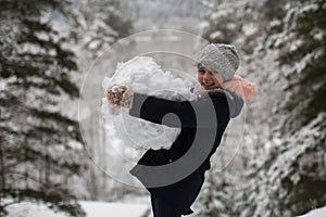 Little cute happy girl sculpts snowman.