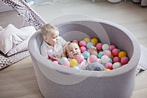 Little cute happy kids play with balls in ball pit in Play room. Birthday party