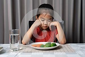 Little cute kid girl refusing to eat healthy vegetables. Children do not like to eat vegetables