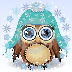 A little cute owl in a blue cap with long ears, a winter owl, shelter from the cold