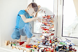 Little cute preschooler boy playing lego toys at home happy smiling, lifestyle children concept