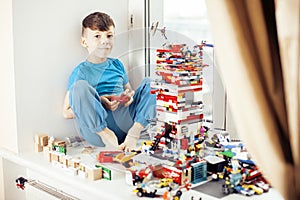 Little cute preschooler boy playing lego toys at home happy smiling, lifestyle children concept