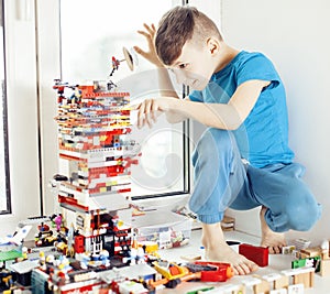 Little cute preschooler boy playing lego toys at home happy smiling, lifestyle children concept