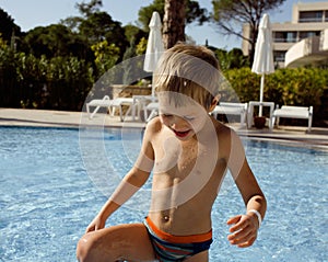 Little cute real boy in swimming pool close up smiling