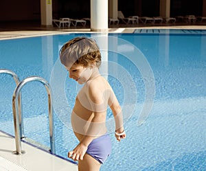 Little cute real boy in swimming pool close up smiling