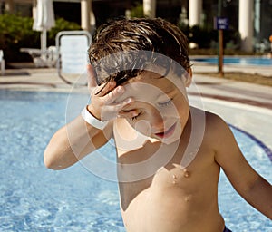 Little cute real boy in swimming pool close up smiling