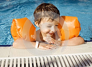 Little cute real boy in swimming pool close up smiling