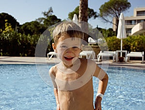 Little cute real boy in swimming pool close up smiling