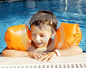 Little cute real boy in swimming pool close up smiling, lifestyle vacations people concept