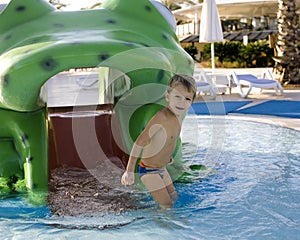 Little cute real boy in swimming pool close up smiling, summer vacation lifestyle people concept