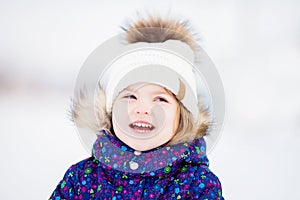 Little cute toddler girl outdoors on a sunny winter day