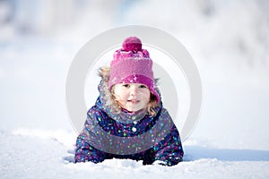 Little cute toddler girl outdoors on a sunny winter day.