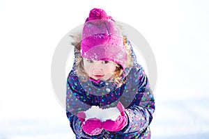 Little cute toddler girl outdoors on a sunny winter day.