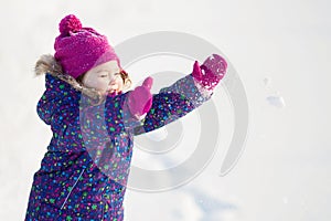 Little cute toddler girl outdoors on a sunny winter day