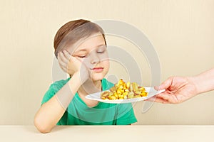 Little cute unhappy boy refuses to eat fries