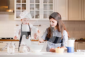 Pequeno en cocineros un sombrero a un delantal a su madre preparar horneando en claro clásico La cocina 