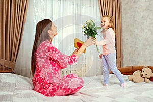 The little daughter congratulates her mother on her mother`s day