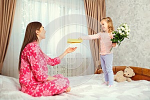 The little daughter congratulates her mother on her mother`s day