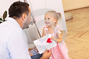 Little daughter congratulating dad with father`s day