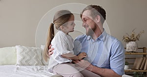 little daughter enjoy playtime with father seated on his laps