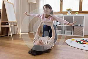 Little daughter enjoy playtime with mother in playroom