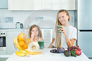 Little daughter and her happy mother drinks green smoothie. Natural antioxidant. Healthy Green food. Mother and daughter