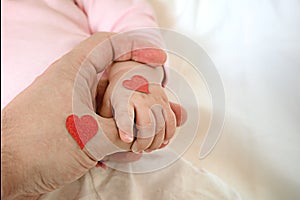 Little daughter holds dad by the finger. hearts for the day of p