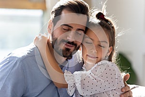 Little daughter hug young dad feeling thankful