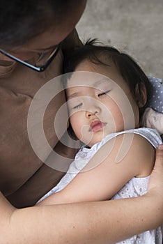 Little daughter lying on moms arm sleeping