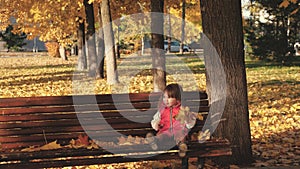 Little daughter and mom play with autumn maple leaves in park. happy childhood concept. little daughter and mother are