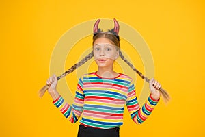 Little demon inside. Girlish temper. Cute but dangerous. Halloween concept. Small adorable child with red horns