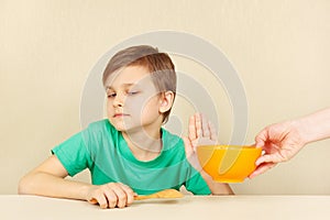 Little discontented boy refuses to eat porridge