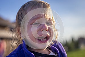 Little disheveled girl crying outdoors